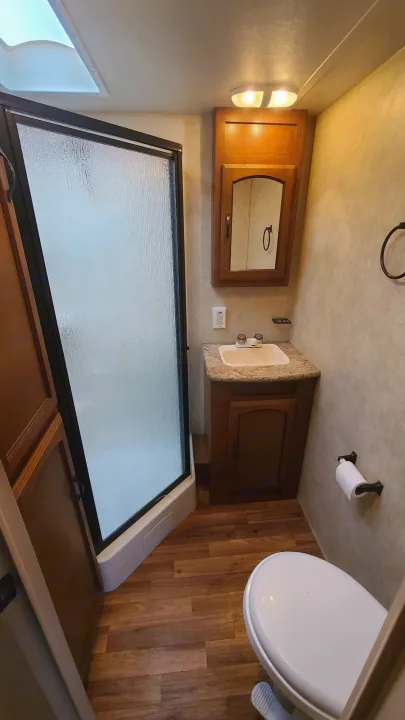 RV rental bathroom: Compact interior with a shower, vanity, sink, and toilet, offering essential comforts for your road trips.. Coachmen salem 2013