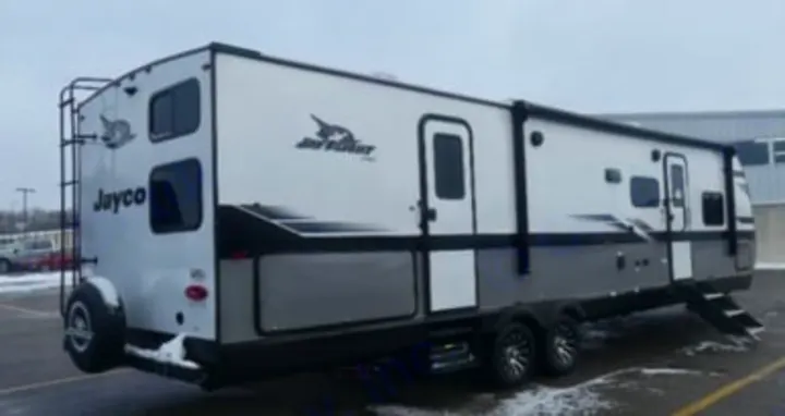 Modern white & gray RV rental. This spacious travel trailer is parked on a snowy lot, ideal for your next outdoor adventure.. Jayco Jay Flight SLX 2024