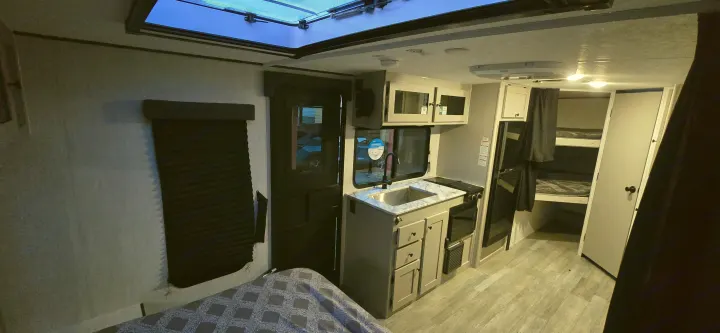 Step inside this RV rental! Features a modern kitchen, cozy bedroom, bunk beds, and bright skylight.. Coachmen Apex 2025