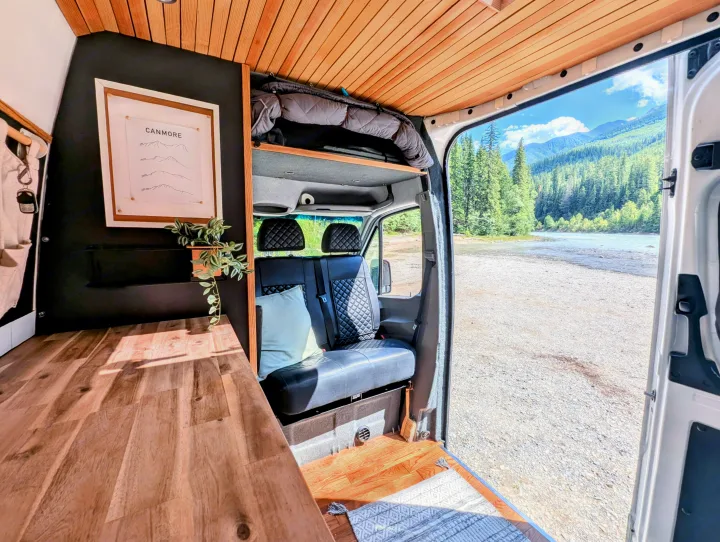 Step into this inviting RV rental: a wood-finished interior featuring mountain art, opening to a stunning river and forest view.. Mercedes-Benz Mercedes Sprinter 2500 2015