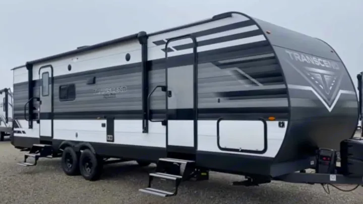 A sleek gray and white travel trailer RV, steps extended for easy access. Ideal for your next rv rental adventure.. xpolar 265bh 2023