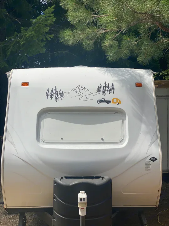 White RV rental, front view, with a decorative mountain and tree decal. Perfect for your next outdoor camping trip.. Cruiser RV Fun Finder X 2011