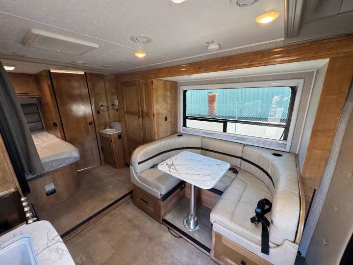 This inviting RV rental interior showcases a cozy dinette with a modern table, a compact bedroom, and a small bathroom.. Coachman Prism Select 24 CB 2021