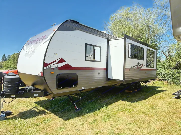 A clean, white & grey Campsite Reserve RV rental, with its slide-out extended, is parked on grass under a clear sky.. Forest River Campsite reserve 26CJ 2025