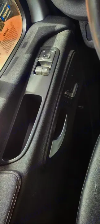 Driver's door panel in an RV rental, featuring window/mirror controls, seat adjustments, and storage cubby.. Jayco Melbourne Prestige 2022