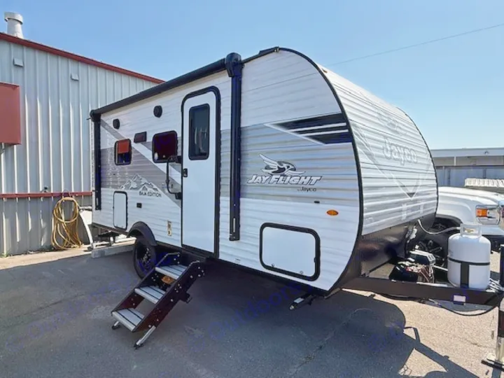 White Jayco Jay Flight travel trailer, an excellent RV rental option. Steps are down, propane tank visible.. JAYCO Jay Flight 2025