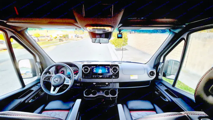 Modern RV rental cabin view showing the spacious dashboard, steering wheel, and open road ahead from the front seats.. Airstream Interstate 2024