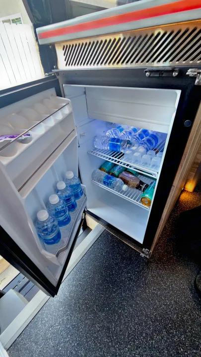 RV rental mini-fridge stocked with Aquafina water and canned drinks, ready for your road trip adventures.. Airstream Interstate 2024