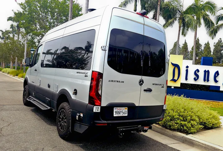 A white Mercedes-Benz Sprinter Airstream Interstate X 4x4 camper van, a perfect rv rental, by the Disneyland sign.. Airstream Interstate 2024