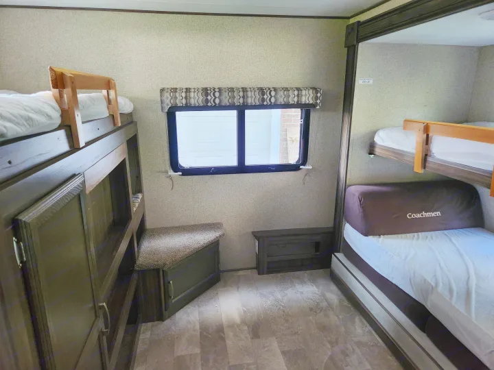 Spacious RV rental bunkhouse interior. Features multiple bunk beds and storage, ideal for families.. Coachmen Apex 2018