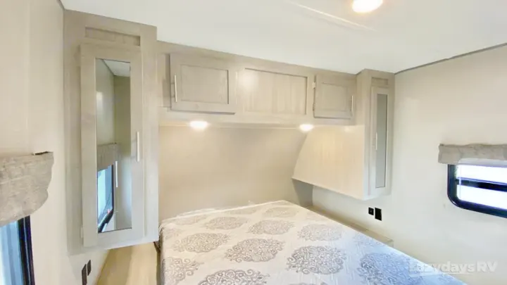RV rental bedroom: cozy interior with a bed, overhead storage, and bedside cabinets. Ideal for your next camper trip.. Coachmen Catalina Legacy Edition 2022