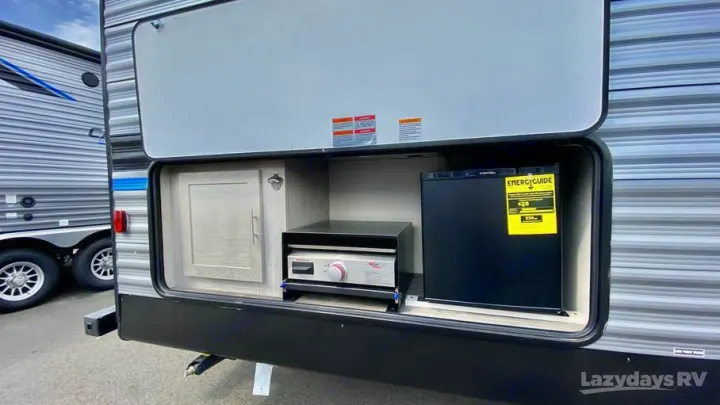 Experience convenient travel with this RV rental's exterior kitchen, featuring a griddle, mini-fridge, and cabinet storage.. Coachmen Catalina Legacy Edition 2022