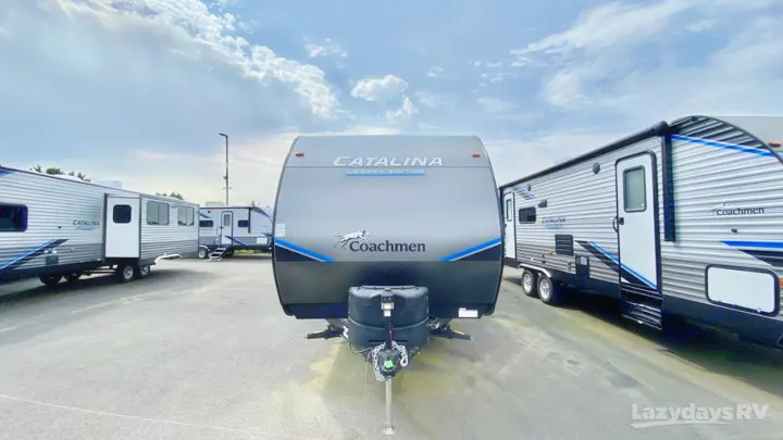 Coachmen Catalina travel trailers, ideal for RV rental. Multiple new RVs are parked at a dealership lot under a cloudy sky.. Coachmen Catalina Legacy Edition 2022