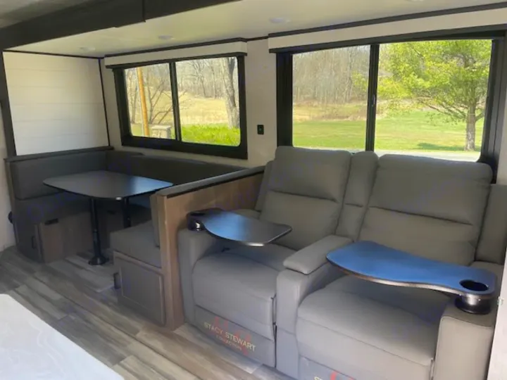 Check out this RV rental's spacious living area featuring a comfy dining booth and power recliners with trays.. Jayco Jay Flight SLX 2024