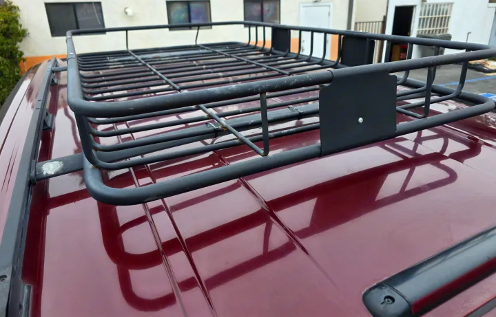 Roof-mounted cargo basket on a maroon vehicle, perfect for extra storage on your RV rental adventure.. Chevrolet Astro 2003