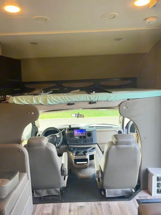 Inside an RV rental: View of the cockpit and overhead bunk bed, featuring ample space for travel comfort.. Jayco Redhawk 2021