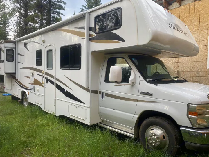 White Sunseeker RV rental, a motorhome with a slide-out, parked on green grass. Ideal for your next adventure.. Forest River Sunseeker 2011