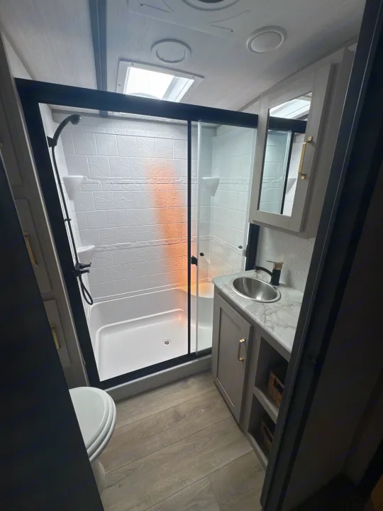 Bright RV bathroom with a walk-in shower, vanity, sink, and toilet, great for any rv rental trip.. Forest River Salem Hemisphere 2024