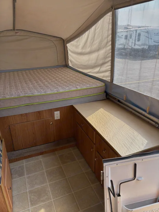 Inside this pop-up rv rental, a cozy bed, cabinet, and floor offer basic camping comforts for your next travel adventure.. Jayco Jay Series 2006