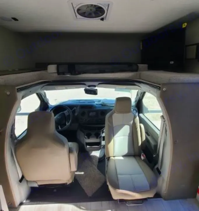 Experience this rv rental! Front cabin, dashboard, two seats, overhead bunk with safety net, roof vent, and TV.. Forest River Coachmen Freelander 2025