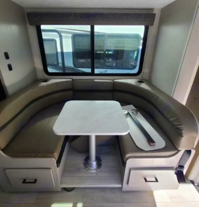 This RV rental features a comfortable U-shaped dinette booth with a table, window view, and built-in storage drawers.. Forest River Coachmen Freelander 2025