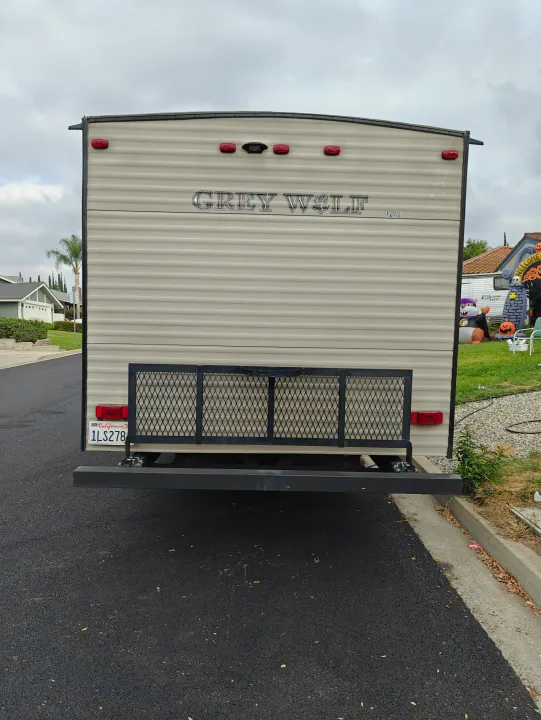 Back of a Grey Wolf rv rental travel trailer, featuring cargo rack, taillights, and CA license plate 1LS278.. Forest River Cherokee Grey Wolf 2016