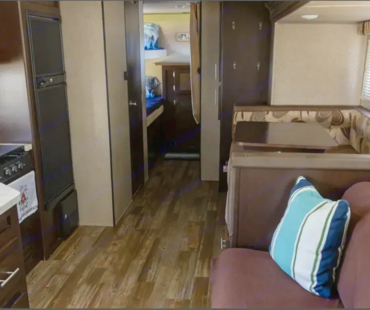 Spacious rv rental interior features a kitchen, dining booth, and rear bunk beds, ideal for family travel.. Forest River Cherokee Grey Wolf 2016