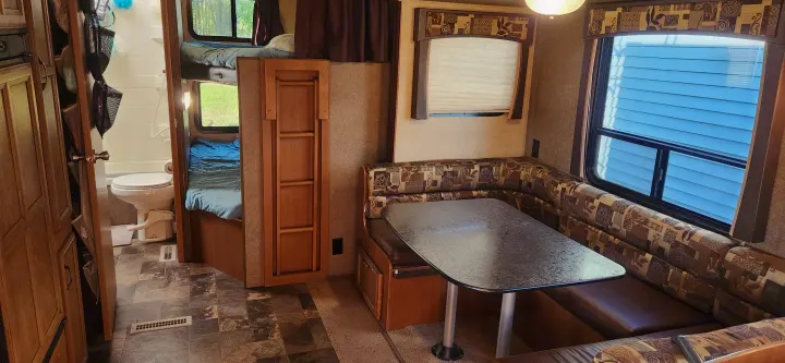 Inside an RV rental: features a U-shaped dinette, bunk beds, and compact bathroom. Ready for adventure!. Starcraft Autumn Ridge 2014