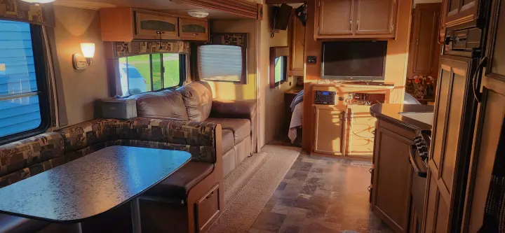 Bright RV rental interior displays dining booth, sofa, entertainment, and kitchen areas clearly.. Starcraft Autumn Ridge 2014