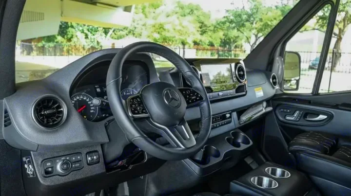 Step inside a premium RV rental! This modern Mercedes-Benz Sprinter cockpit features a sleek dashboard, steering wheel, and large display.. Mercedes Benz Sprinter 2500 2024