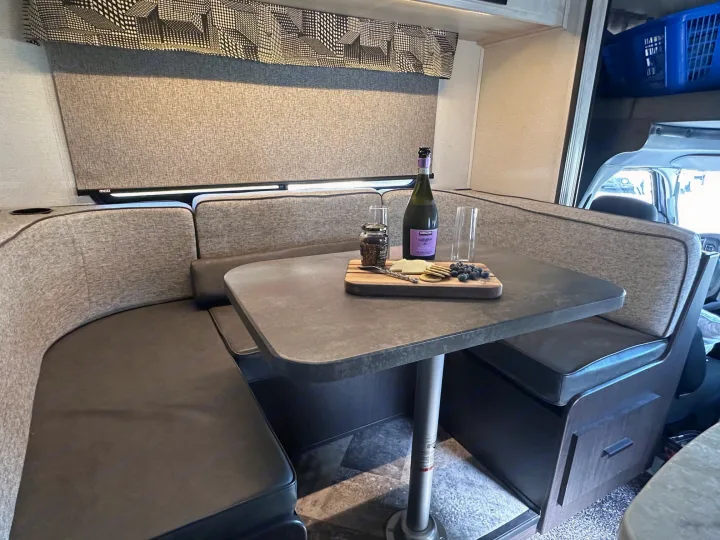 Relax in this RV rental dinette, set with snacks and drinks, offering comfort for your camping and travel adventures.. Forest River Sunseeker Classic 2021