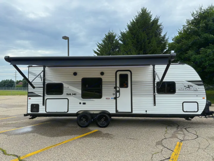 This white Jayco travel trailer with its awning extended is a great rv rental for outdoor adventures.. Jayco Jay Flight 2025