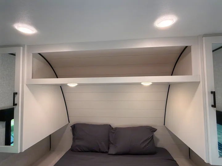 RV rental bedroom interior: modern design with shiplap headboard, overhead storage, and integrated task lighting. Cozy and functional.. Jayco Jay Flight 2025