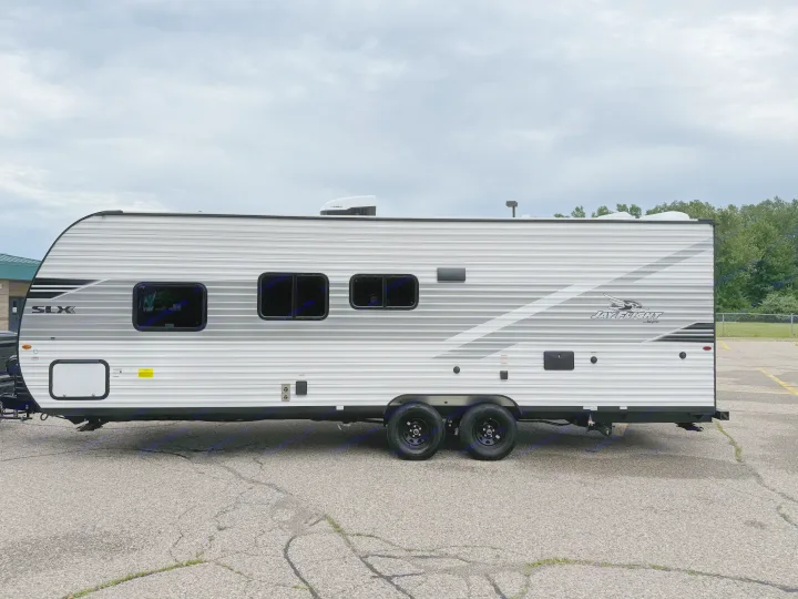 Side view of a white and gray travel trailer, equipped with windows and roof AC, perfect for RV rental.. Jayco Jay Flight 2025