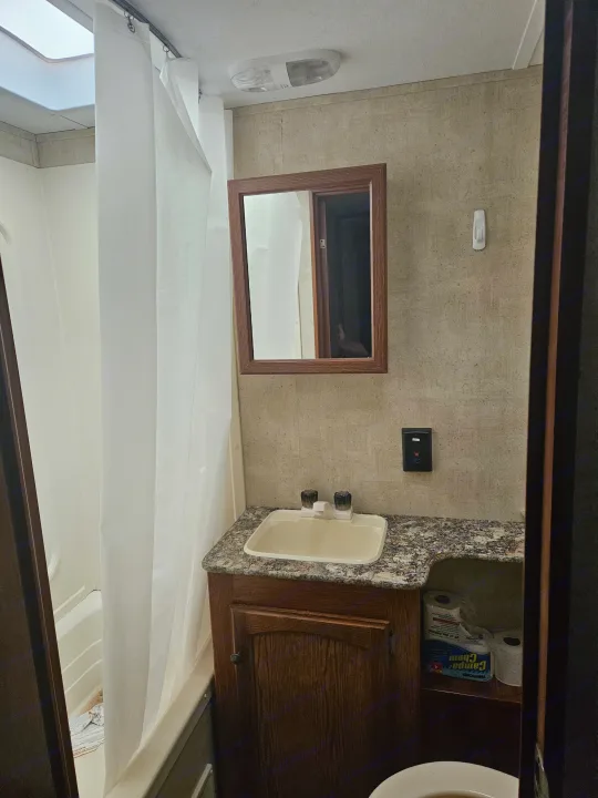 RV rental bathroom with shower, sink vanity, mirrored medicine cabinet, and toilet. A functional space for your journey.. Keystone RV Hideout 2015