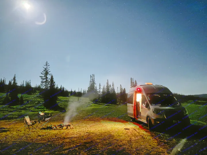Night camping with an RV rental under a starry sky and bright moon. A camper van, campfire, and chairs complete the peaceful outdoor scene.. Ford Transit 2022