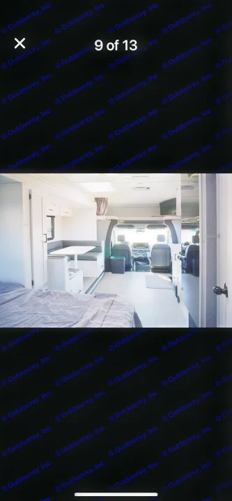 Modern rv rental interior with a cozy bed, dinette, and front cab. Bright, spacious living space.. east to west entrada 2023