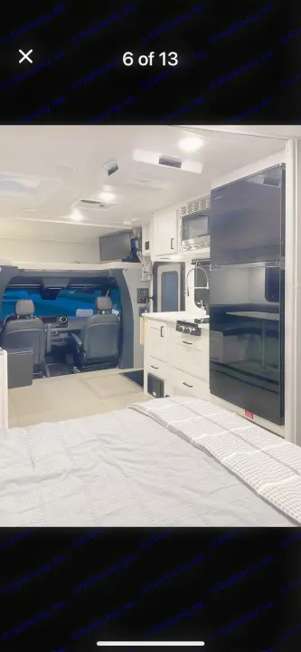 Modern RV rental interior showing bedroom area, full kitchen, & front cabin. Compact living for adventures.. east to west entrada 2023