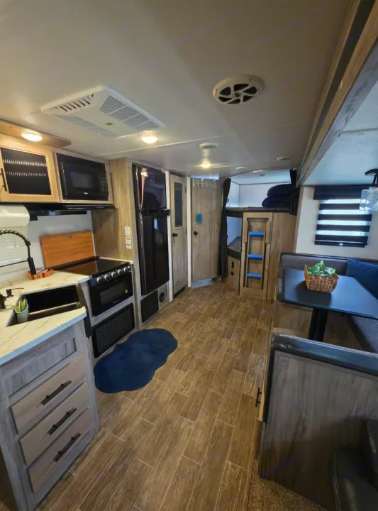 Spacious RV rental interior featuring a modern kitchen, cozy dinette, and bunk beds for family comfort.. Forest River Cherokee Alpha Wolf 2021