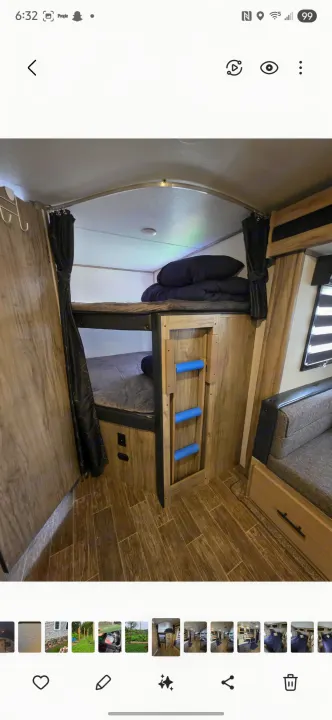 Cozy RV rental bunk bed area with two bunks, a ladder, curtains, and a nearby sofa, perfect for compact sleeping.. Forest River Cherokee Alpha Wolf 2021