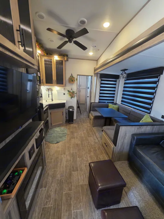 Step inside this comfortable RV rental, showcasing its modern kitchen, cozy dinette, and inviting living space with wood-look floors.. Forest River Cherokee Arctic Wolf 2021