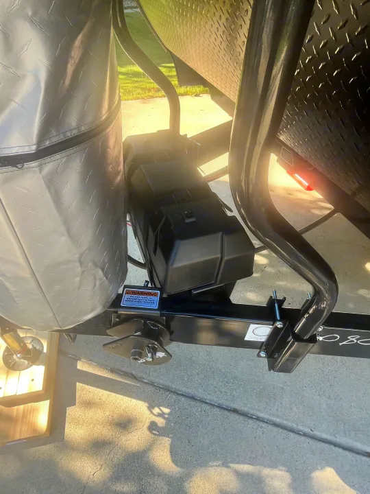 Hitch detail of an RV rental: black battery box, grey diamond plate propane cover, and "WARNING" label on the frame.. 58TBP0BPXS77L3080 Go Play 2025