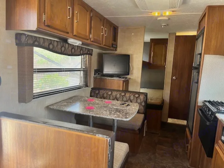 RV rental interior: Dinette, kitchen, & a glimpse of the bedroom in this travel-ready camper.. Keystone RV Summerland 2015
