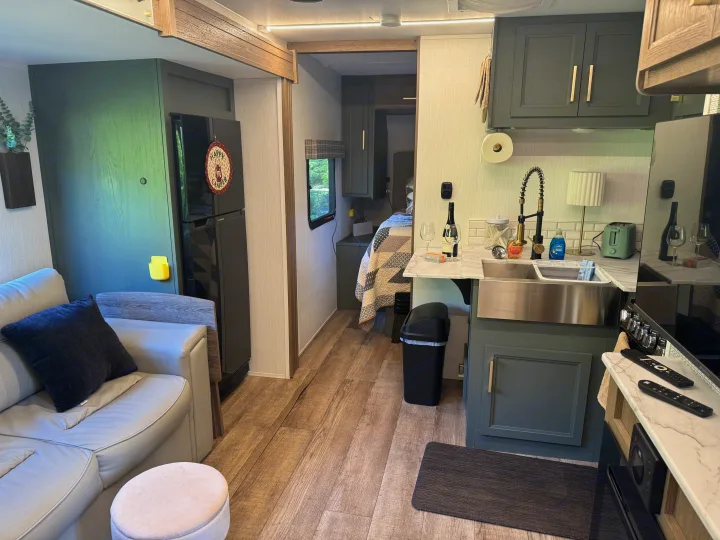 Modern rv rental interior with full kitchen, living space with sofa, and bedroom access. Stylish and comfortable for travel.. Heartland RVs Eddie Bauer 2024