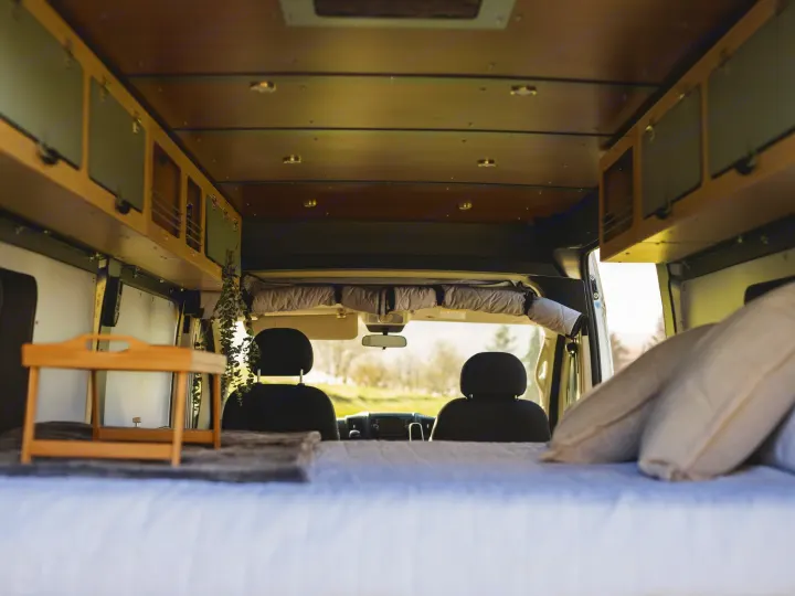 Spacious RV rental interior. From the bed, view driver/passenger seats & wooden overhead cabinets. Ready for adventure!. Wayfarer Walt 2021