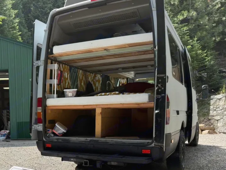 Looking into the back of this RV rental van, revealing a clever bunk bed setup and storage for mobile living.. Dodge Sprinter 2006