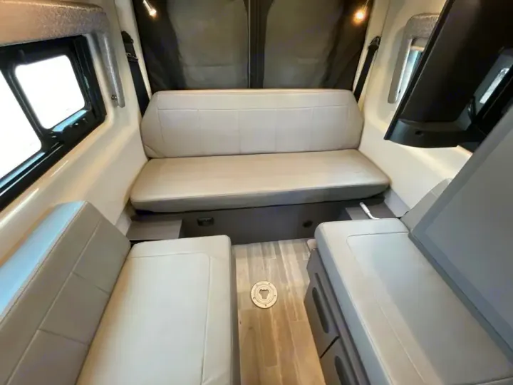 RV rental interior: A versatile dinette with light gray seating, likely converting to a bed. Spacious and comfortable.. Thor Tranquility 2022