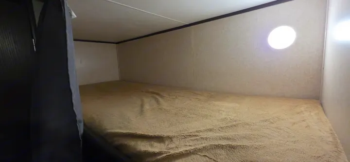 Cozy RV rental bunk bed space featuring a soft brown blanket and bright circular light.. Jayco Jay Flight SLX 2018