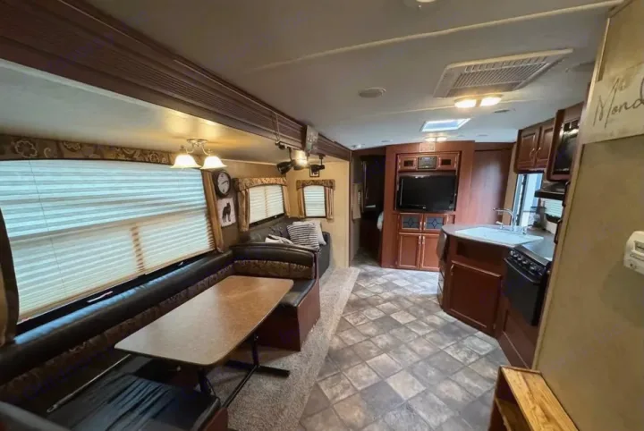An RV rental's inviting interior: dinette, lounge, full kitchen, and entertainment center offer comfort on the road.. Evergreen RV Sun Valley 2014