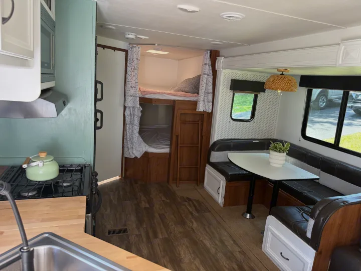 Cozy RV rental interior featuring a renovated kitchen, dining area, and bunk beds for comfortable travel.. Gulf Stream Conquest 2016
